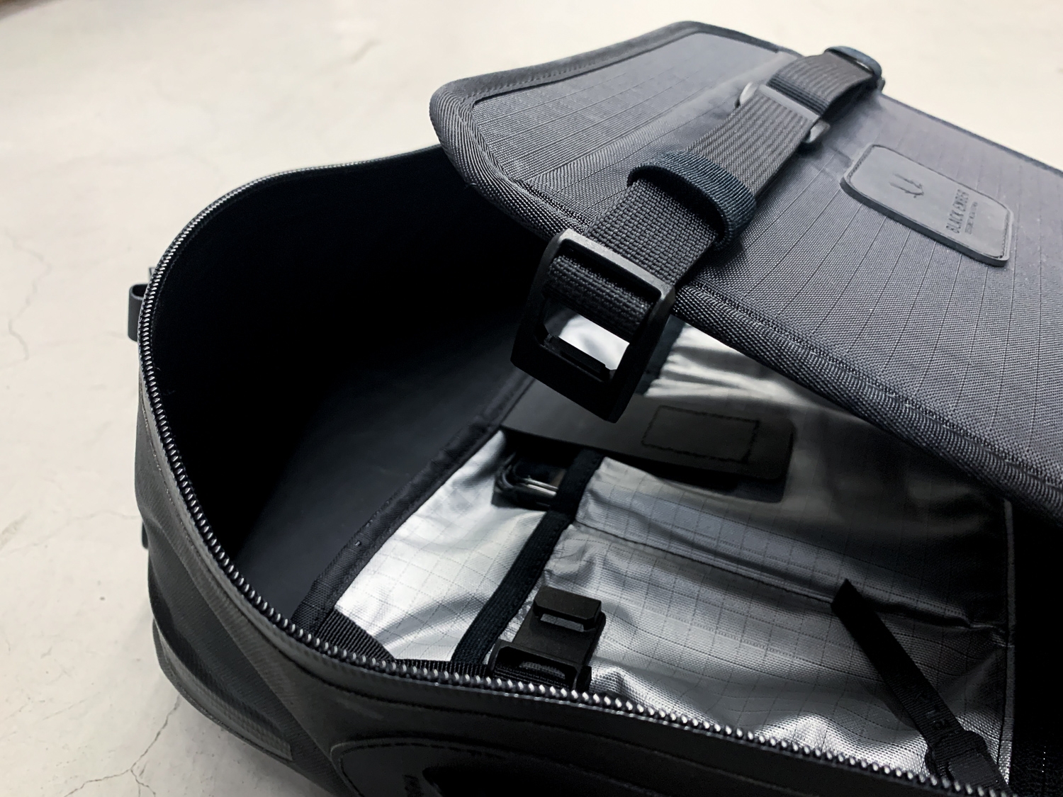 The black minimalist backpack comes from Black Ember with a compression divider to keep things flat and organized.